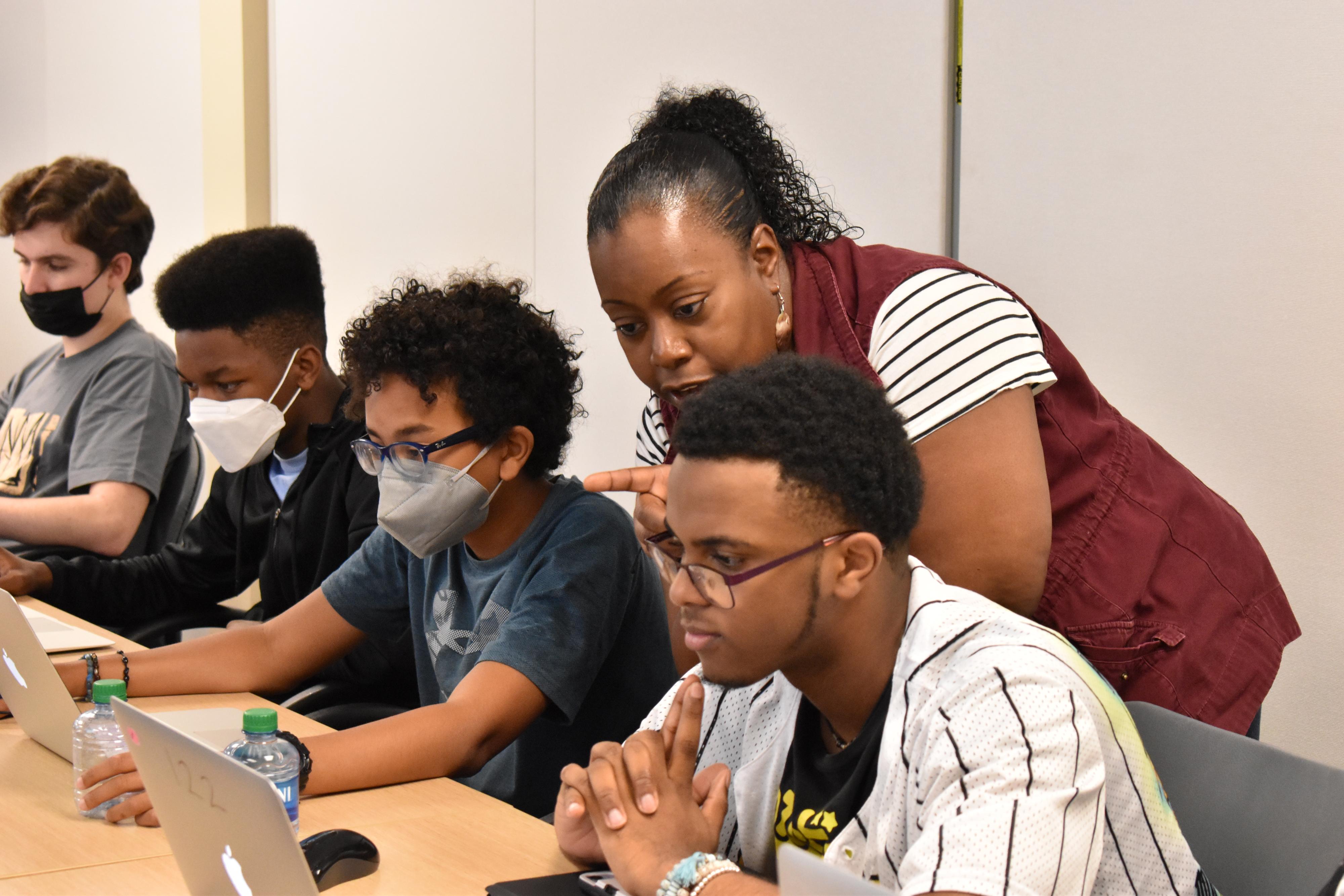 Students working on computers with an instructor